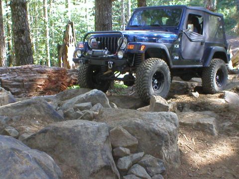 2005 Jeep Wrangler - This blue 2005 Jeep Wrangler tackles a challenging rocky trail, its off-road capabilities.