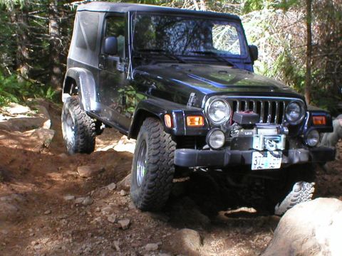 2005 Jeep Wrangler - This Jeep Wrangler navigates a challenging off-road path with large rocks and dirt.