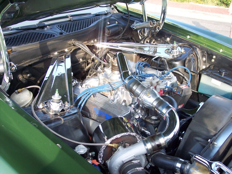 Engine bay with chrome valve covers, turbocharger, and blue spark plug wires