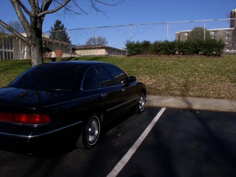 1997 Ford Crown Victoria - This black 1997 Ford Crown Victoria is parked in a lot, showing its 3/4 front profile.