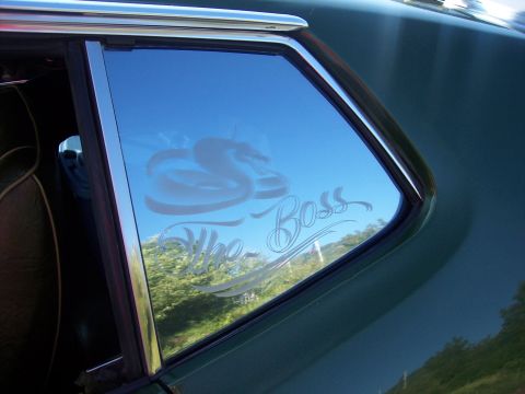 1973 Ford Mustang - Decal on car window reflects trees and sky. The text reads 'The Boss'.