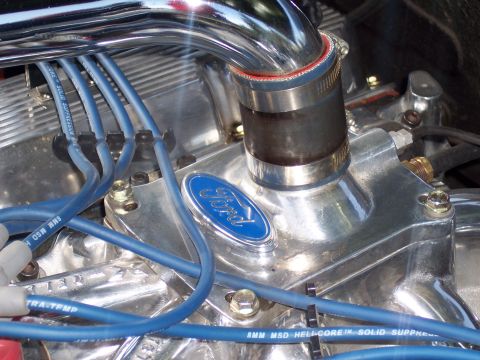 1973 Ford Mustang - Engine bay detail a Ford V8 engine with chrome accents and blue spark plug wires.