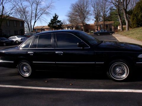 1997 Ford Crown Victoria - Side profile of a black 1997 Ford Crown Victoria sedan parked on asphalt.