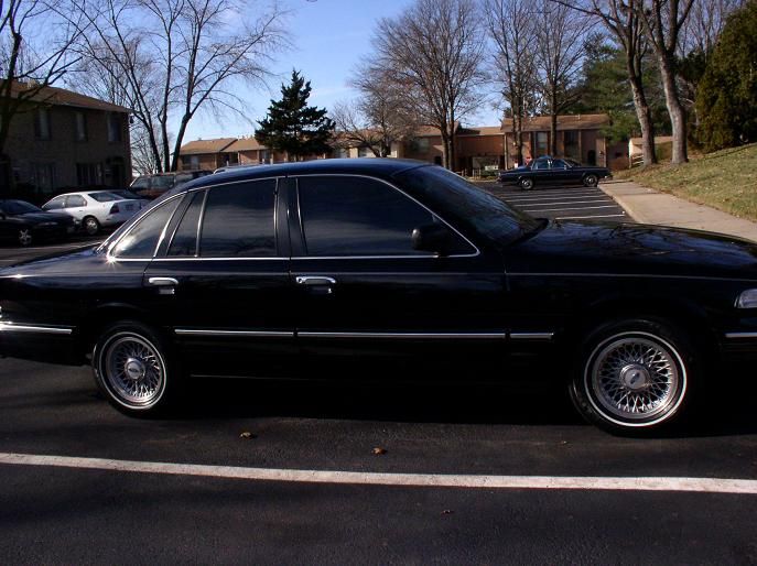 1997 Ford Crown Victoria sedan, side view, black paint, chrome wheels