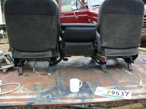 1988 Ford Bronco - Car seats and a license plate are visible, with a red vehicle in the background.