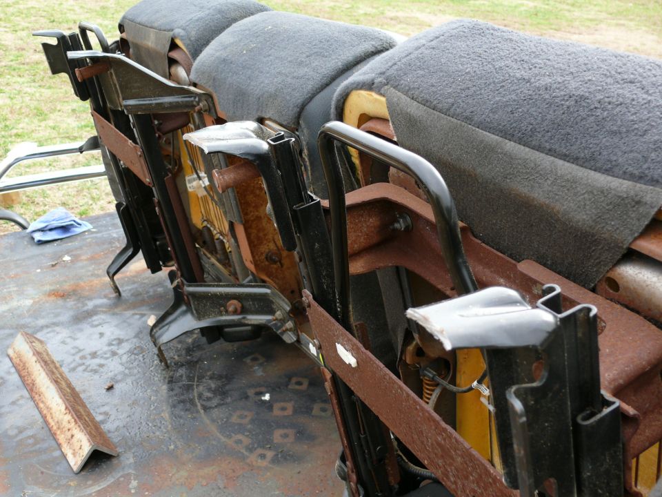 Rusted seat frames with grey upholstery and black metal brackets