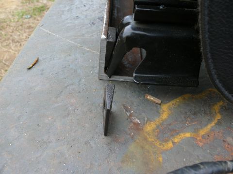 1988 Ford Bronco - A metal wedge lies near a seat bracket on a rusty surface, with a SuperMotors logo visible at the bottom right.