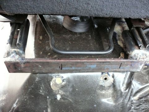 1988 Ford Bronco - Close-up of a vehicle's interior seat mounting bracket, showing signs of modification.