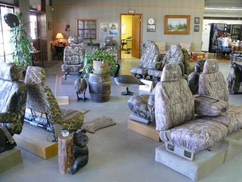 1988 Ford Bronco - Vehicle seats with camouflage covers are arranged in a showroom setting.