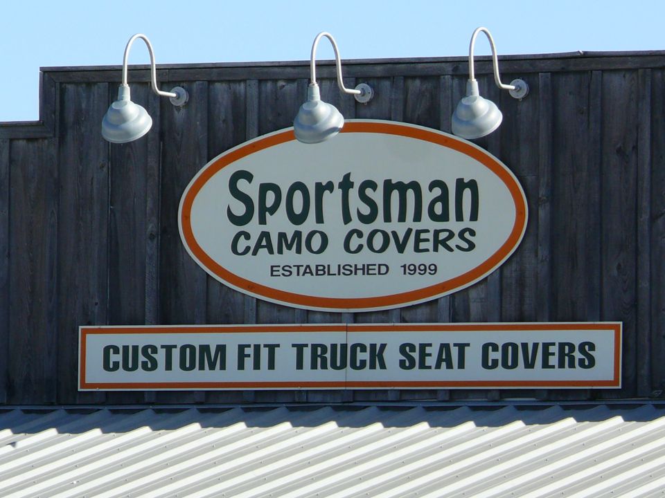Sign for Sportsman Camo Covers, established 1999, advertising custom fit truck seat covers