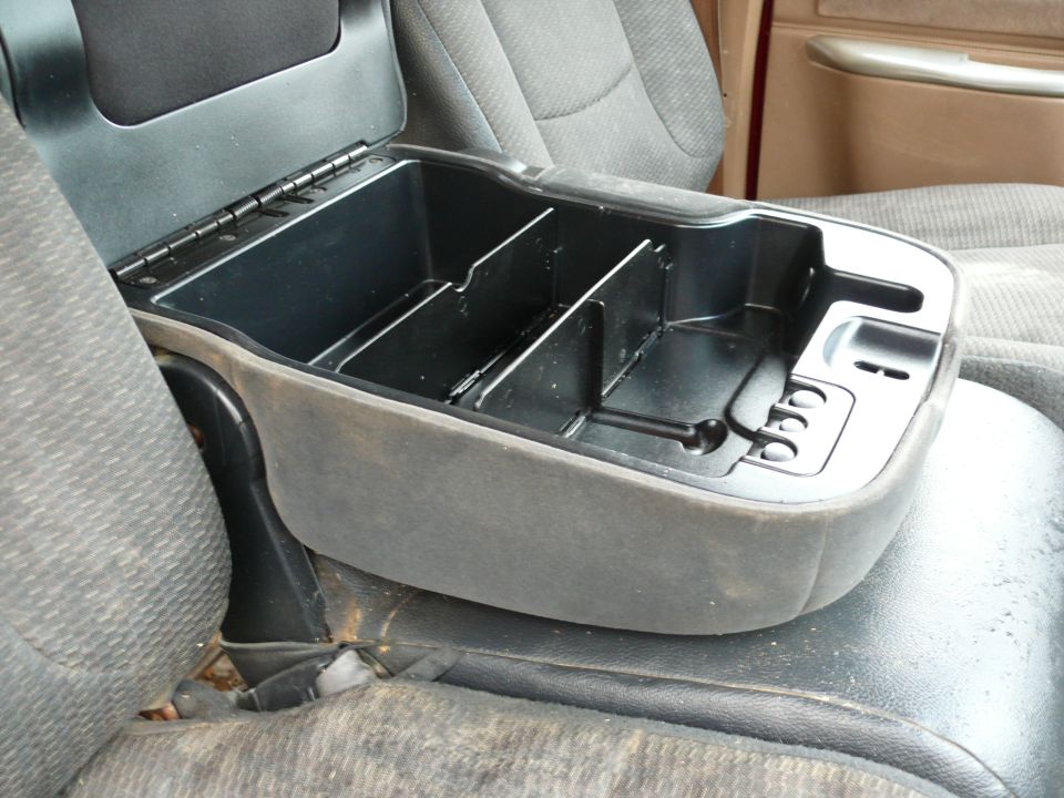 Center console storage compartment with dividers, gray fabric upholstery, and black plastic lid