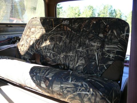 1988 Ford Bronco - Camouflage seat covers are installed on the rear bench seat of a vehicle.