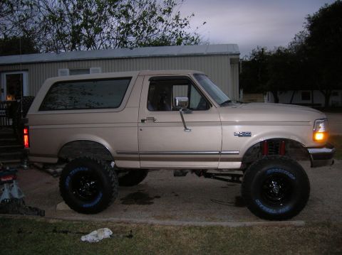 1996 Ford Bronco - This lifted tan 1996 Ford Bronco features large off-road tires and a raised suspension system.