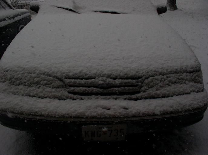 1997 Ford Crown Victoria front covered in snow, license plate KWG-735
