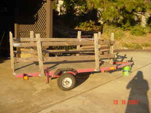 1995 Ford Bronco - A red utility trailer with wooden sides sits on a concrete surface.