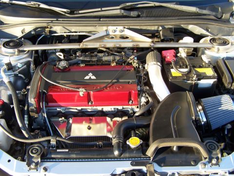 1995 Ford Probe - Engine bay of a Mitsubishi vehicle, a red valve cover and "TURBO" branding.