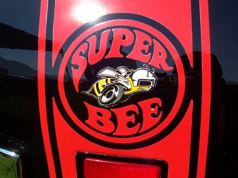 1973 Ford Mustang - Close-up of a Super Bee decal on a black vehicle. The decal features a bee mascot and the words 'SUPER BEE'.