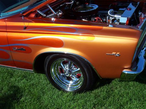 1973 Ford Mustang - A custom hot rod with flame paint and chrome accents sits on grass.