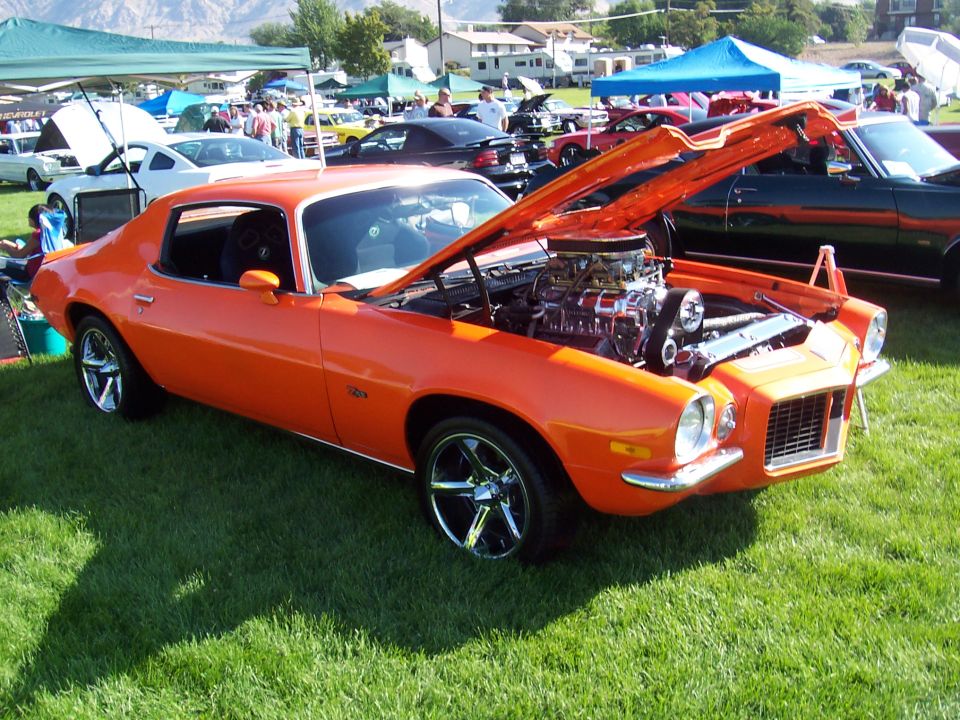 Orange 1970 Chevrolet Camaro with hood open, showing a supercharged engine