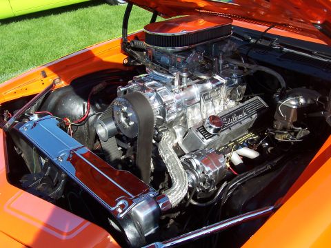 1973 Ford Mustang - Customized V8 engine with chrome supercharger and intake manifold. Engine bay is painted orange.