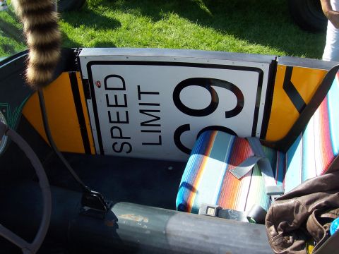 1973 Ford Mustang - Interior view of a car a 'SPEED LIMIT 65' sign and colorful striped upholstery.
