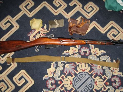 2004 Ford F-150 - A rifle, leather ammo pouch, and canvas strap are laid out on a patterned rug.