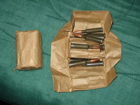 2004 Ford F-150 - Ammunition cartridges are shown packaged in brown paper on a green surface.