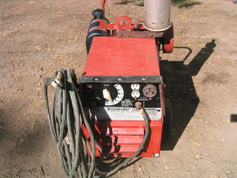 1973 Ford F-100 - A red Lincoln Weldanpower 150 welder sits on the ground, showing its control panel and coiled cables.