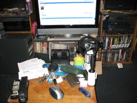 1997 Ford Crown Victoria - A cluttered desk features a computer monitor, gaming accessories, and various everyday items.