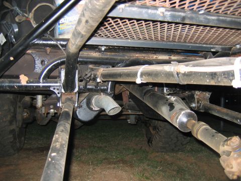 1992 Ford Mustang - The underside of a heavily modified vehicle, likely for off-road use, shows complex mechanical components and a roll cage structure.