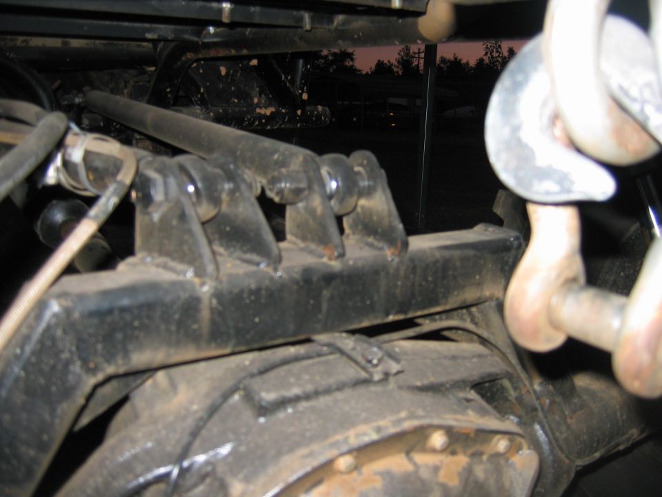 Close-up of a vehicle's rear axle and suspension with large tow hooks