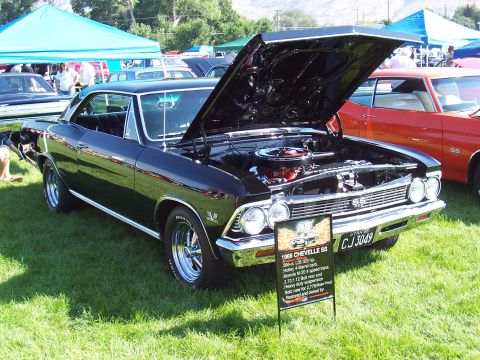 1973 Ford Mustang - A black 1966 Chevrolet Chevelle SS is displayed with its hood open, alongside other vehicles at an outdoor car show.
