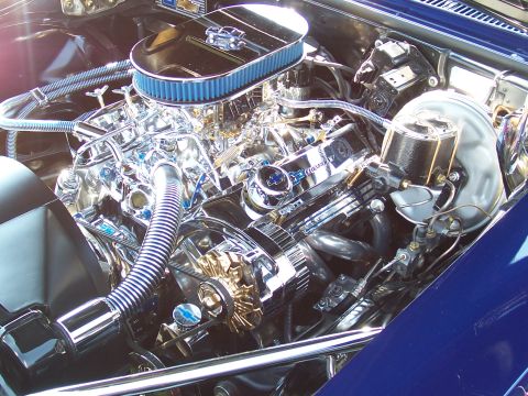 1973 Ford Mustang - The engine bay features a highly polished V8 engine with custom chrome components and a blue air filter.