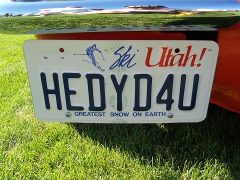 1973 Ford Mustang - A Utah license plate with the phrase 'Greatest Snow on Earth' is attached to an orange vehicle.