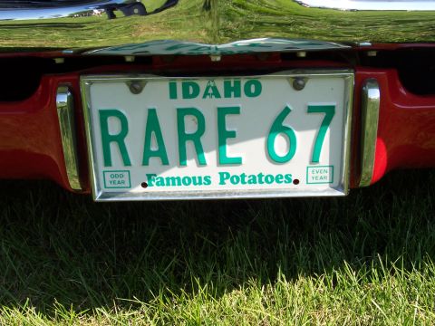 1973 Ford Mustang - An Idaho license plate reading 'RARE 67' is mounted on the rear of a red vehicle.