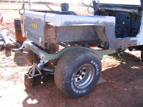 1980 Jeep CJ7 - The rear body section of a Jeep is shown, supported by jack stands and undergoing some form of repair or modification.