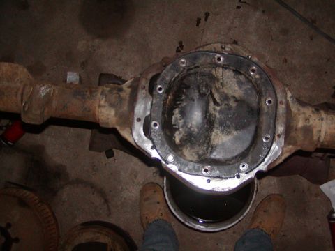 1991 Ford Bronco - A differential axle housing is shown with its cover removed, positioned above a bucket of fluid.