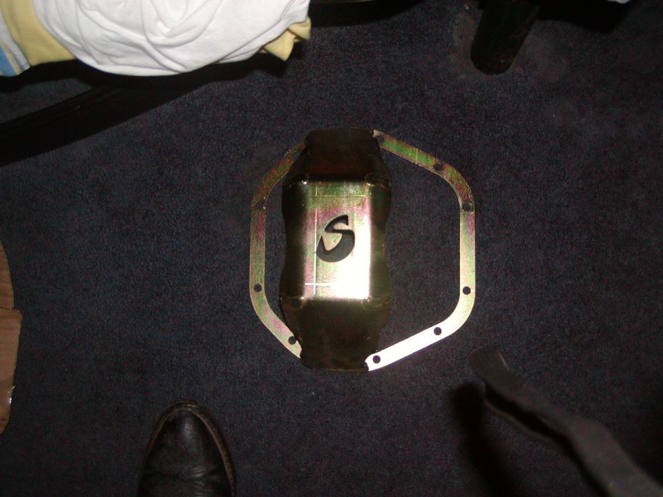 oil pan gasket with S logo on dark carpet