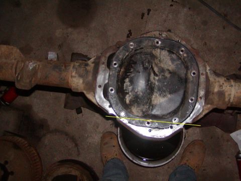 1991 Ford Bronco - A rear differential assembly is shown, with a yellow line drawn across its cover for measurement purposes.