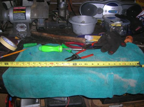 1985 Ford Bronco - A collection of tools and a grinder are laid out on a workbench.