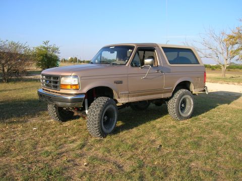 1996 Ford Bronco - This lifted 1996 Ford Bronco is shown from a 3/4 front angle, parked outdoors on a sunny day.