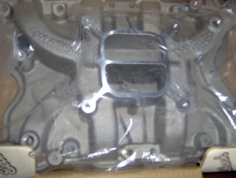 1978 Ford Bronco - This is a close-up view of an aluminum intake manifold, likely a performance part, still in its packaging.