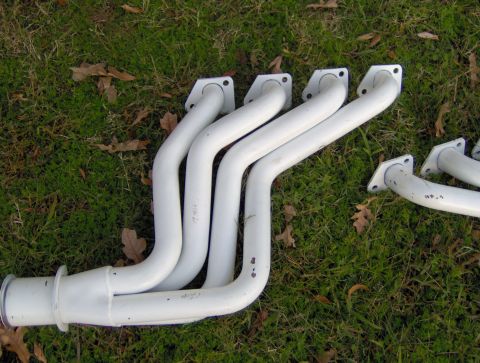 1978 Ford Bronco - Pair of white exhaust headers on the grass.