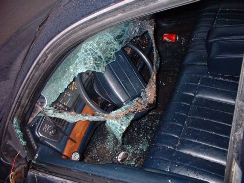 1996 Ford Crown Victoria - The interior of a 1996 Ford Crown Victoria shows extensive damage from a broken window, with glass fragments scattered across the dashboard…