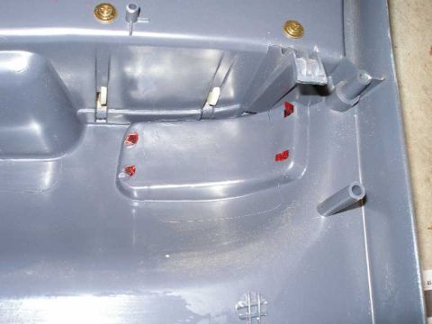 2001 Ford Crown Victoria - Close-up of a gray plastic interior door panel, showing mounting hardware and red reflectors.