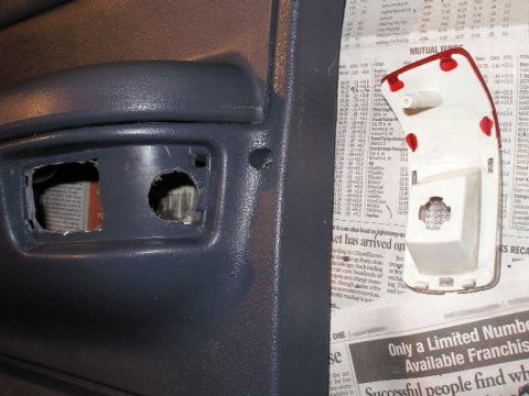 2001 Ford Crown Victoria - A car door panel with a removed courtesy lamp is shown next to the lamp assembly, with newspaper underneath.