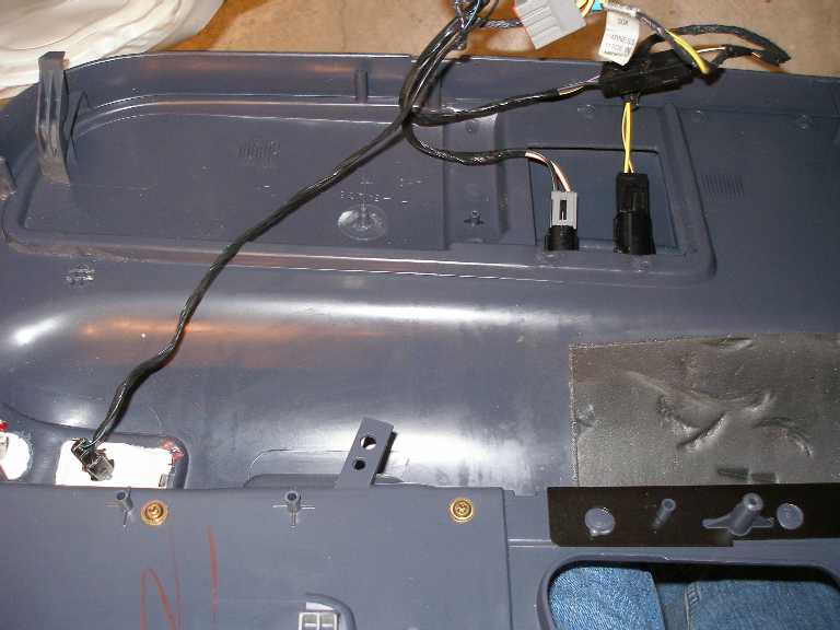 Reinstalling the driver's door. Note the two harnesses and connectors for the fuel and trunk release buttons.