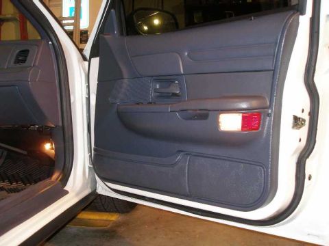 2001 Ford Crown Victoria - The interior door panel of a 2001 Ford Crown Victoria features a lit courtesy lamp.