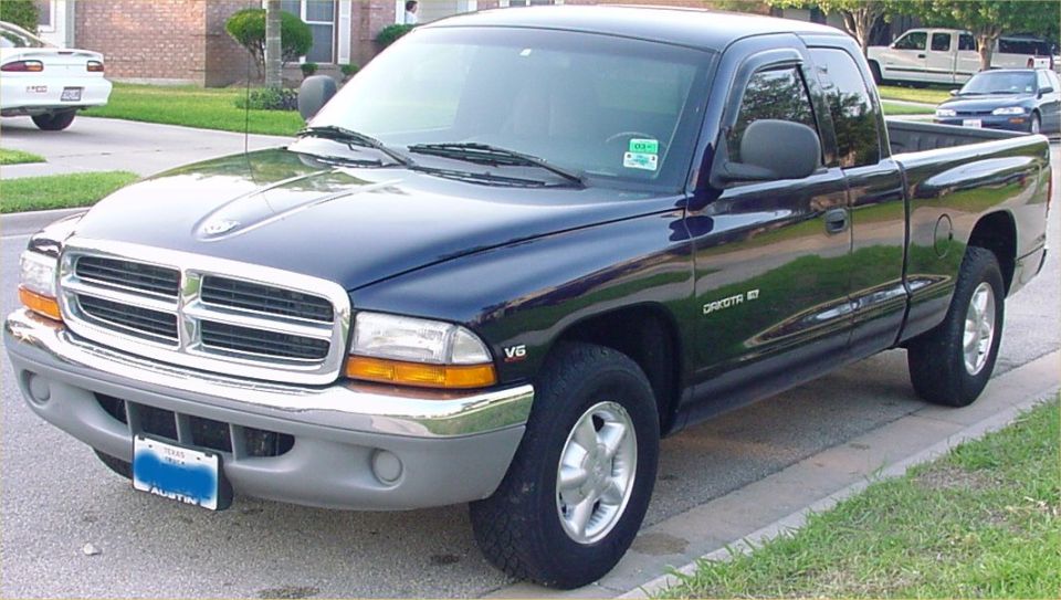Black Dodge Dakota SLT extended cab pickup, front three-quarter, in suburban driveway