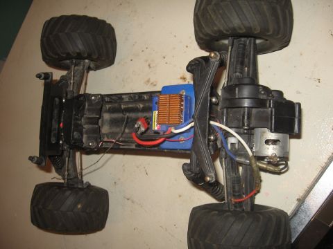 1979 Ford Bronco - The underside of a remote-controlled monster truck chassis is shown, its motor and electronic components.